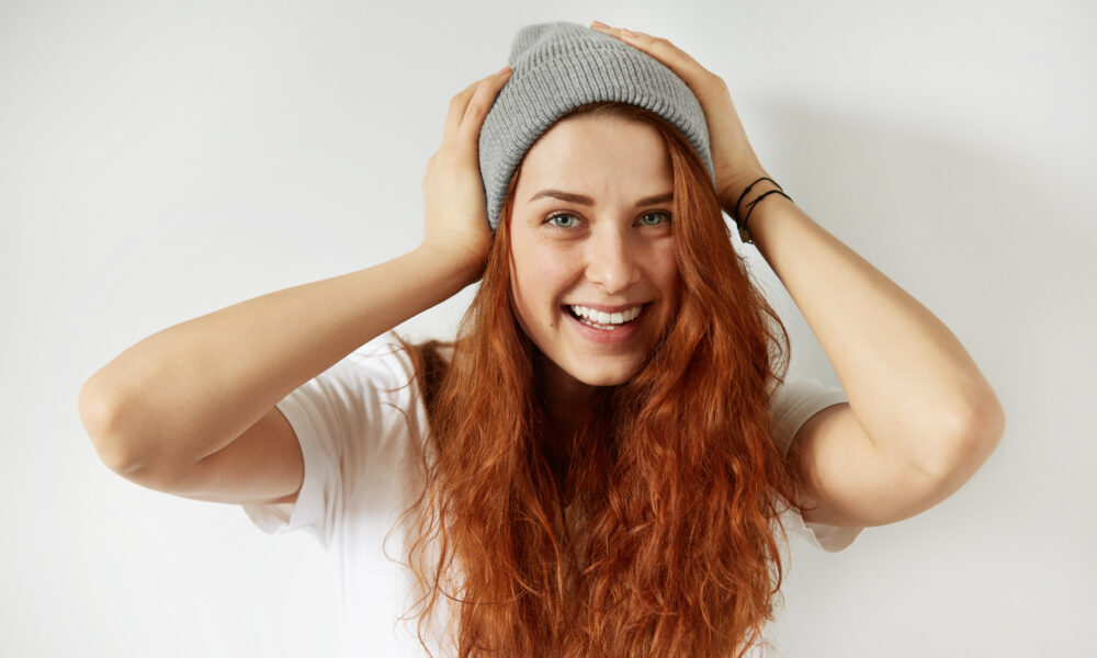 piekna wesola mloda kobieta z zdrowa piegowata skora patrzac i usmiechniety