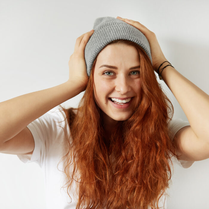 piekna wesola mloda kobieta z zdrowa piegowata skora patrzac i usmiechniety