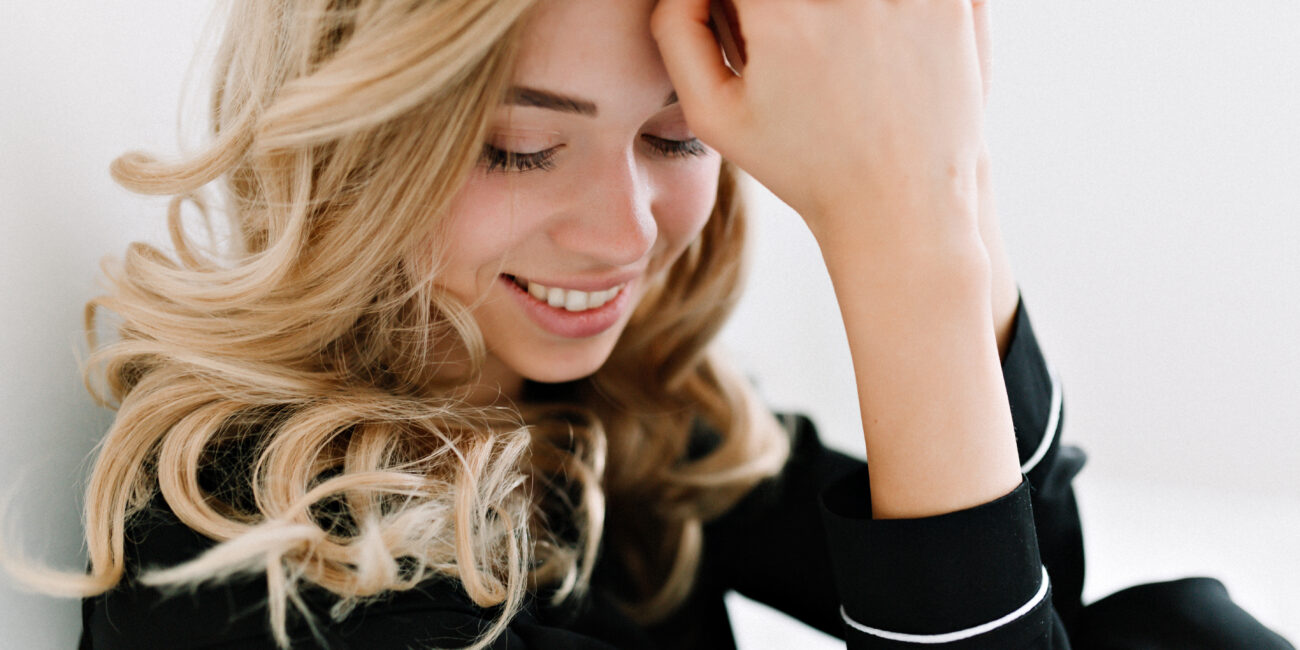 Kobieta z długimi włosami w kolorze ciepłego miodowego blondu, modna koloryzacja 2026.