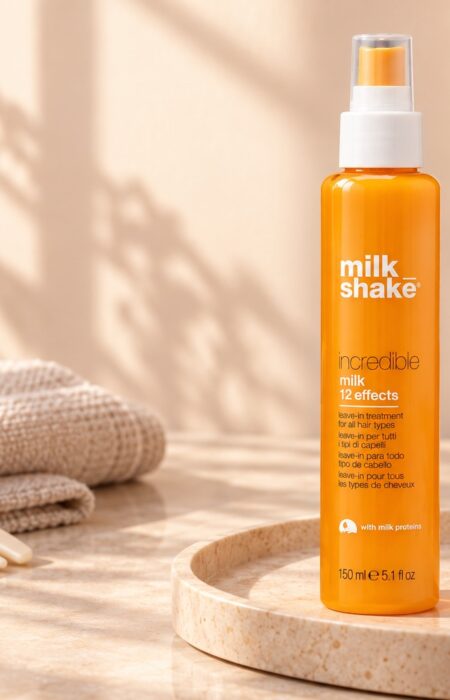 Pomarańczowa butelka Milk Shake Incredible Milk 150 ml obok jasnego grzebienia
