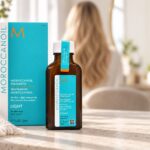 Butelka Moroccanoil Treatment Light 50 ml i turkusowe pudełko na jasnym blacie