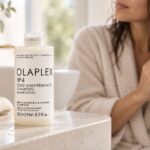 Olaplex No.4 Bond Maintenance Shampoo 250 ml na blacie, w tle kobieta z wilgotnymi włosami