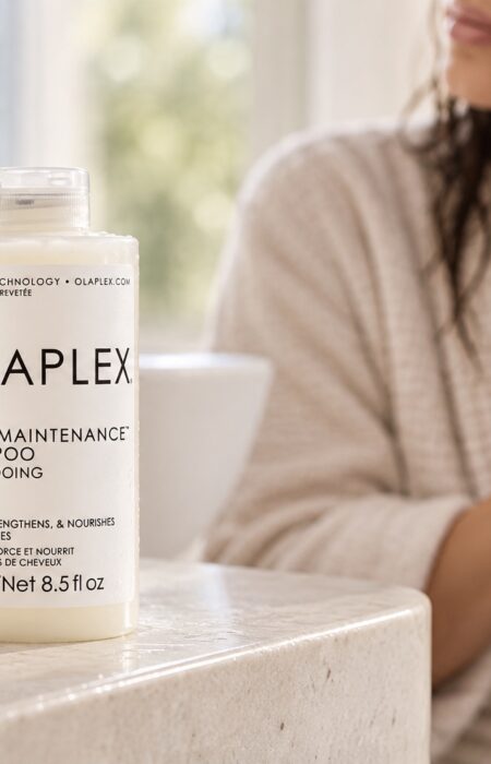 Olaplex No.4 Bond Maintenance Shampoo 250 ml na blacie, w tle kobieta z wilgotnymi włosami