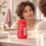 Czerwone opakowanie pudru OSiS Dust It 10 g na toaletce, w tle krótka fryzura