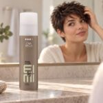 Wella EIMI Pearl Styler na toaletce, w tle kobieta układająca krótkie włosy