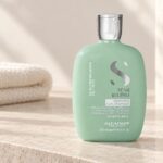 Miętowa butelka Alfaparf Semi di Lino Balancing Low Shampoo 250 ml na jasnej półce
