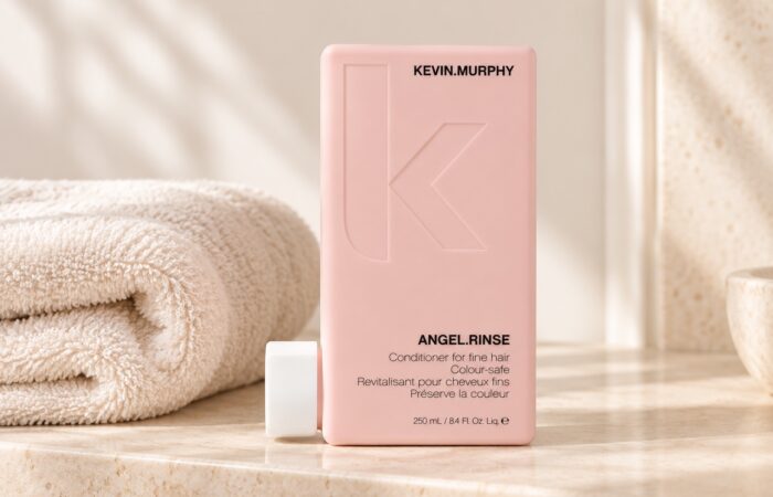 Różowa butelka odżywki Kevin Murphy Angel.Rinse 250 ml obok jasnego ręcznika