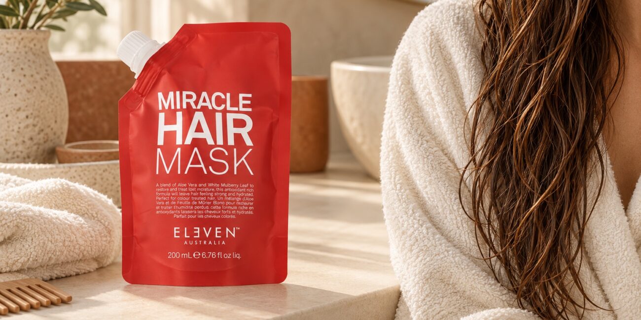 Czerwone opakowanie Eleven Australia Miracle Hair Mask 200 ml przy ręczniku i wilgotnych włosach