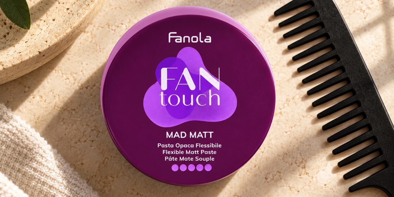 Fioletowe opakowanie pasty Fanola Mad Matt obok czarnego grzebienia.