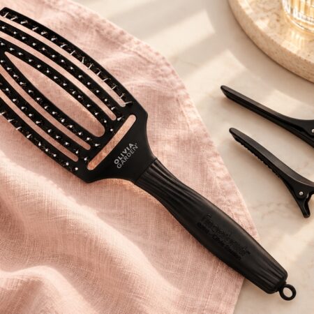 Czarna szczotka Olivia Garden Finger Brush Combo Medium i dwa klipsy do wydzielania pasm.