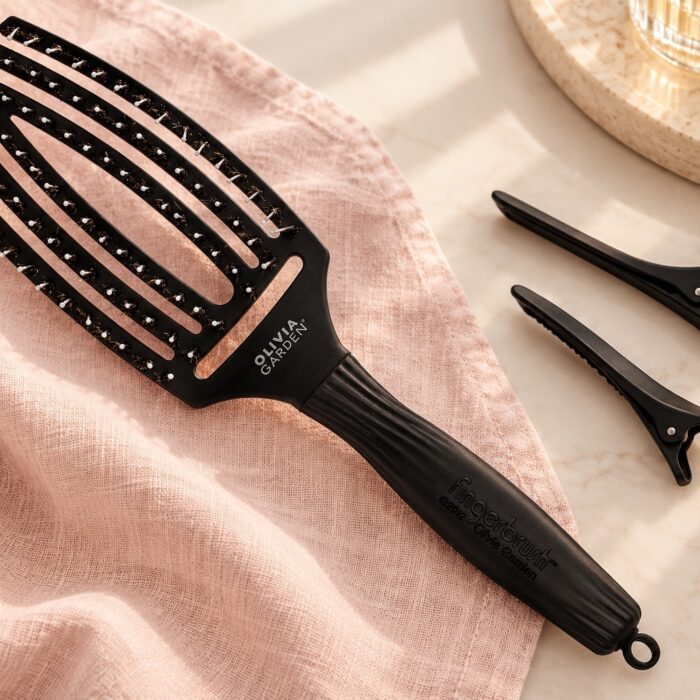 Czarna szczotka Olivia Garden Finger Brush Combo Medium i dwa klipsy do wydzielania pasm.