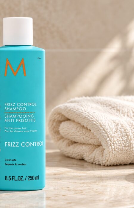 Moroccanoil Frizz Control Shampoo 250 ml na jasnym blacie obok kremowego ręcznika