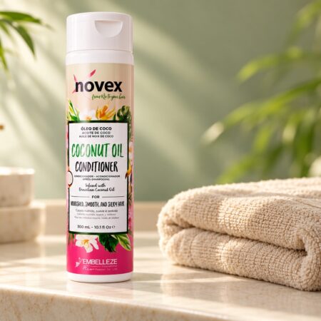 Butelka odżywki Novex Coconut Oil 300 ml na jasnej półce obok ręcznika.