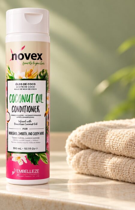 Butelka odżywki Novex Coconut Oil 300 ml na jasnej półce obok ręcznika.