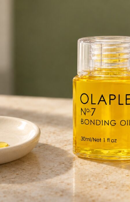 Butelka Olaplex No.7 Bonding Oil 30 ml i dwie krople olejku na ceramicznym naczyniu