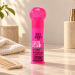 Różowe opakowanie kremu TIGI Bed Head After Party 100 ml na jasnym tle
